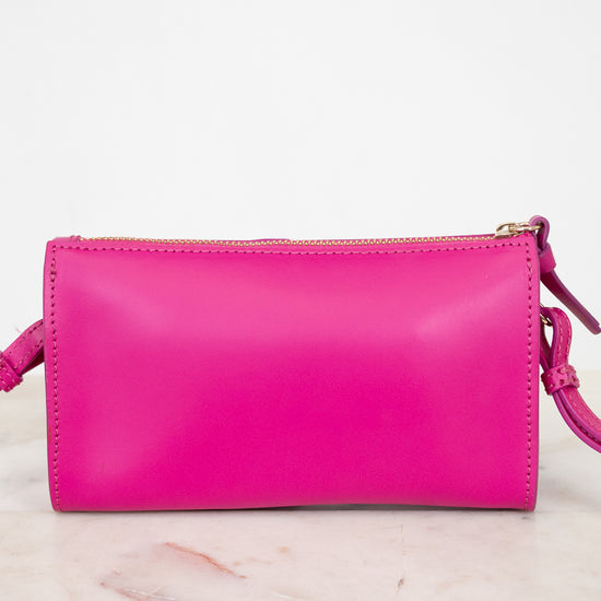 Pink crossbody handbag on a marble surface
