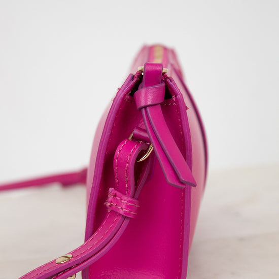 Pink handbag with gold accents on a light background