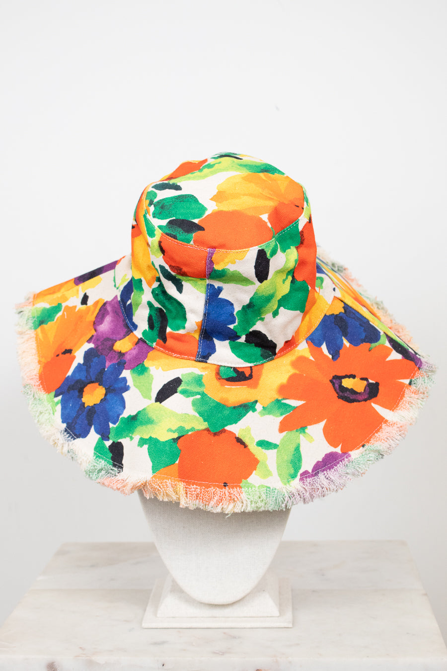 Colorful floral bucket hat with fringe on a white background