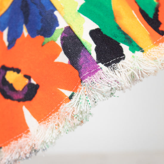 Colorful floral patterned bucket hat with tassels on a white background