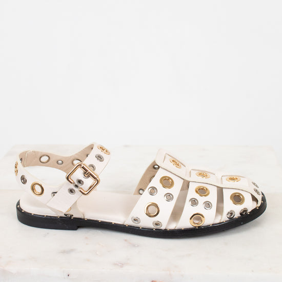 White sandals with gold and silver  embellishments on a white background