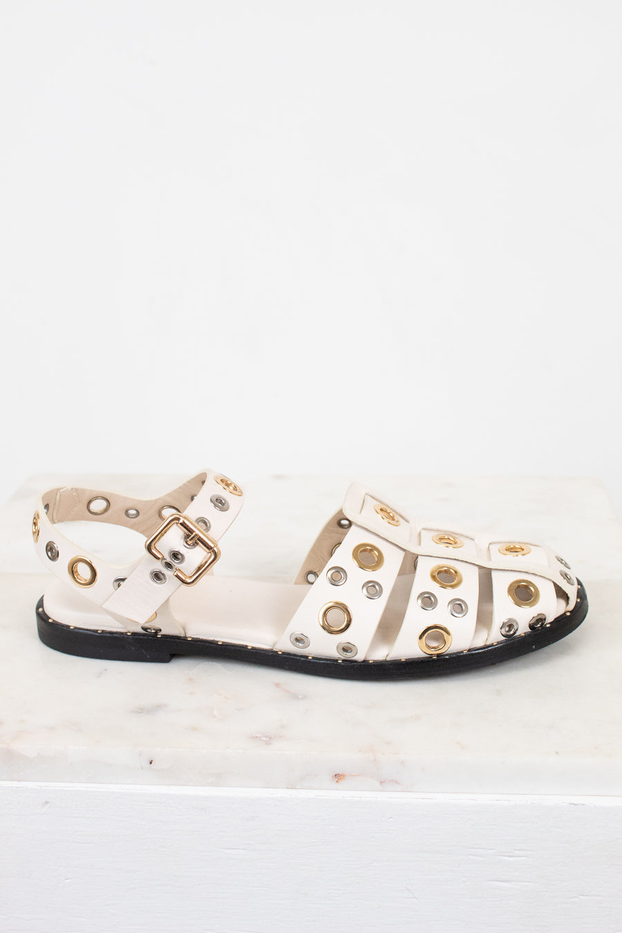 White sandals with gold and silver  embellishments on a white background