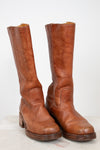 Pair of brown leather knee-high boots on a white background