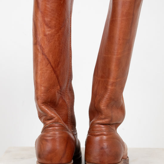 Pair of brown leather knee-high boots on a white background