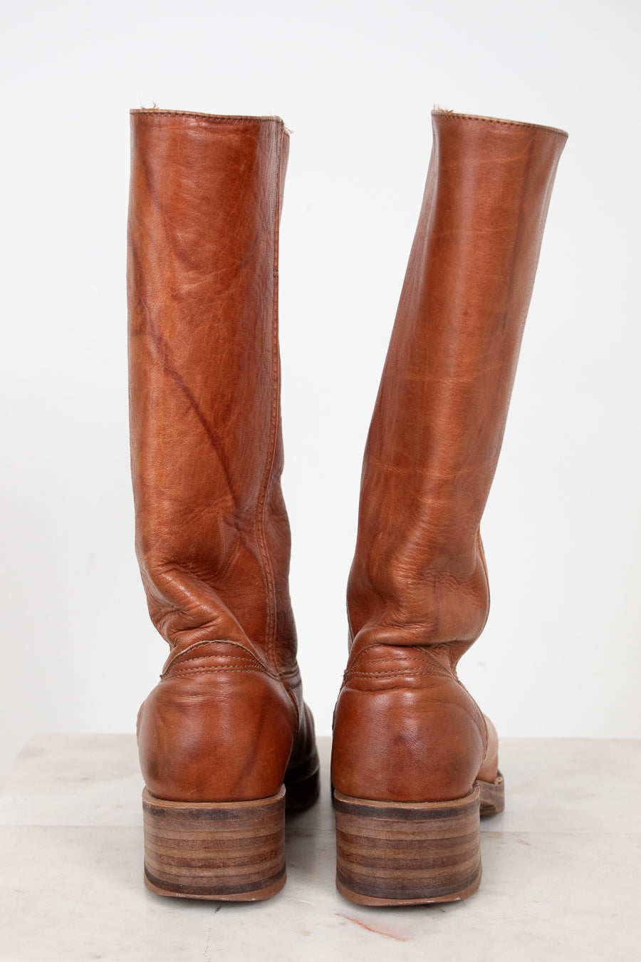Pair of brown leather knee-high boots on a white background