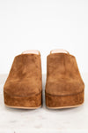 Pair of brown suede clogs on a white background