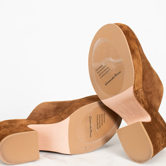 Brown suede shoes with beige soles on a white background