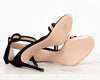 Black high-heeled shoes with beige insole on a white background