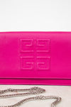 A close-up of a bright pink Givenchy envelope clutch bag with the brand's signature embossed logo on the front flap and a silver chain strap resting below it.