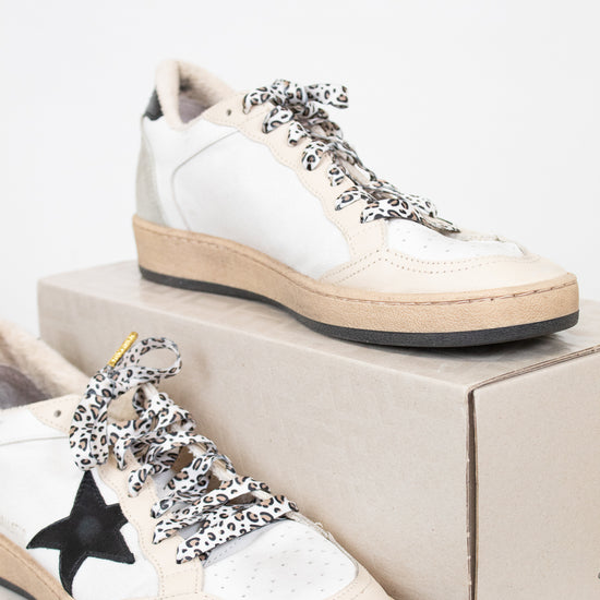 White sneakers with decorative laces on a white background
