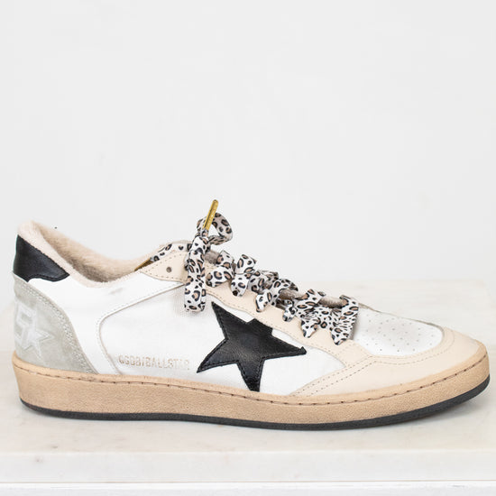 White sneaker with black star and embellishments on a white background