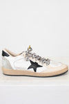 White sneaker with black star and embellishments on a white background