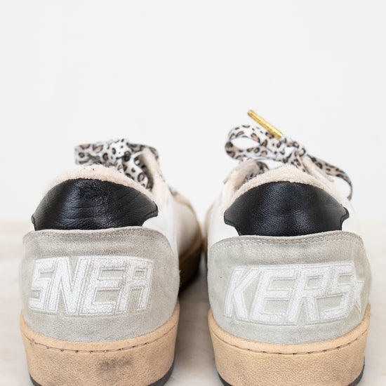 Pair of light gray sneakers with 'Sneakers branding on a white background