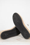 Close-up of a pair of shoes with black soles on a light background