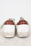 Pair of white sneakers with brown accents and 'Golden Goose' branding on a light background