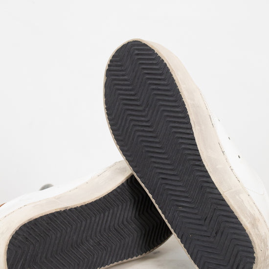 Close-up of a pair of sneakers with black soles on a light gray background