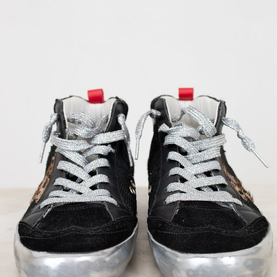 Black high-top sneakers with silver soles on a light background