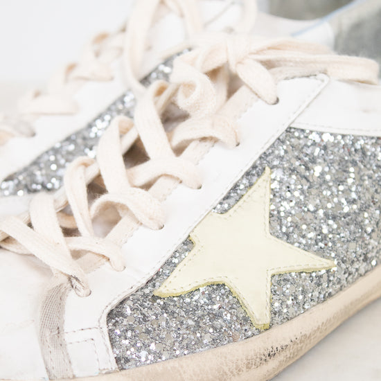 White sneaker with glittery details and star detail on a light background
