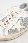 White sneaker with glittery details and star detail on a light background