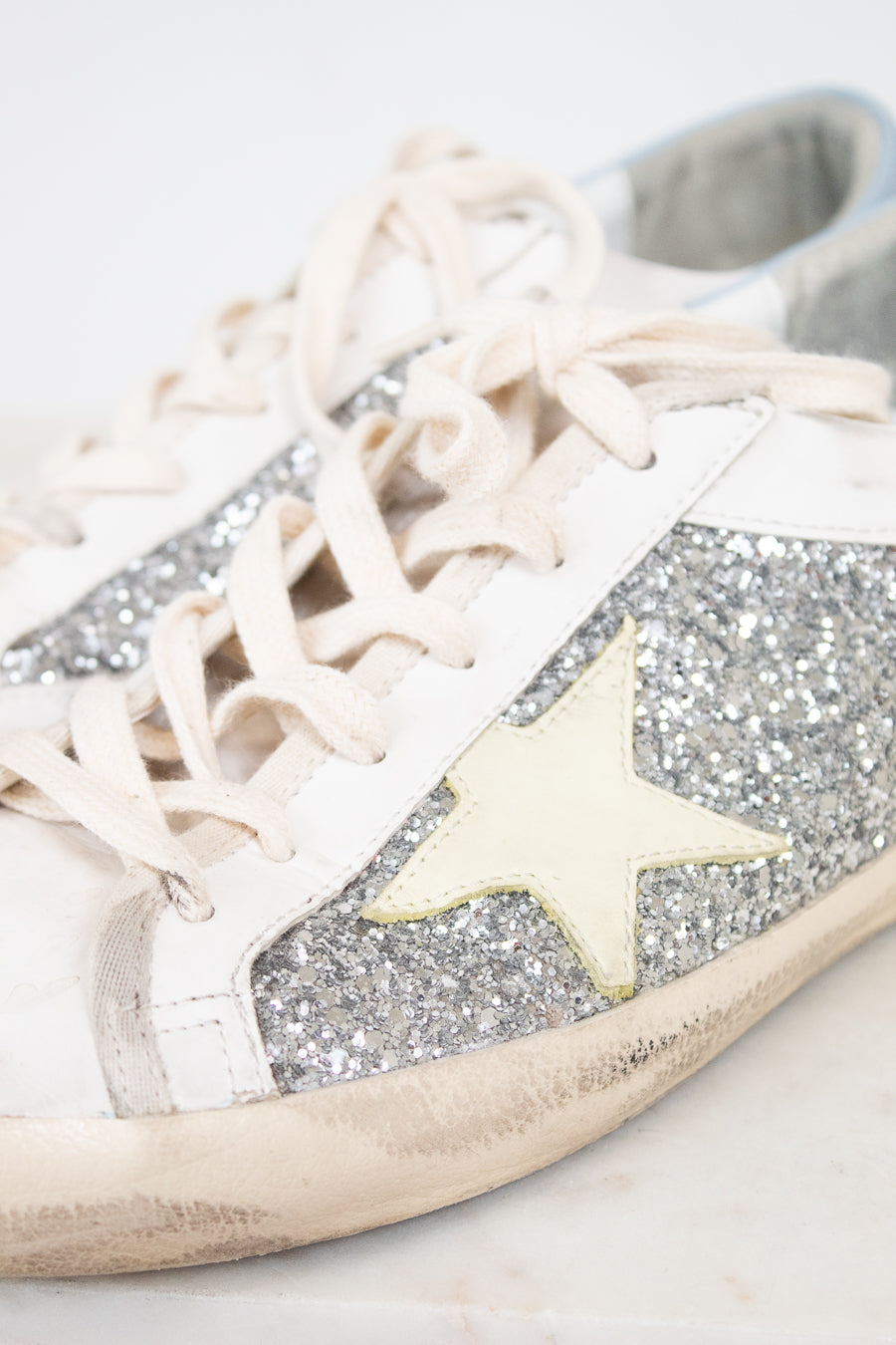 White sneaker with glittery details and star detail on a light background