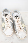 Pair of glittery sneakers with white laces on a light background