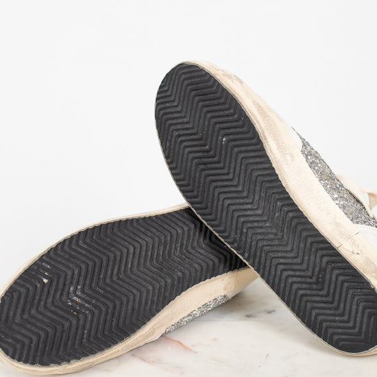 Close-up of a pair of shoes with textured soles on a light background