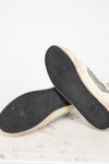 Close-up of a pair of shoes with textured soles on a light background
