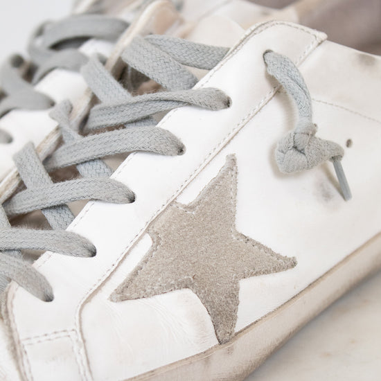 White sneakers with gray stars and laces on a light background