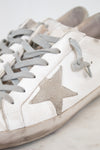 White sneakers with gray stars and laces on a light background