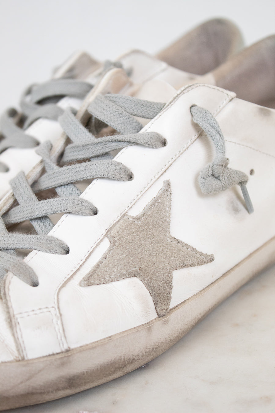 White sneakers with gray stars and laces on a light background