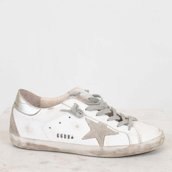 Silver sneaker with a star design on a light gray background