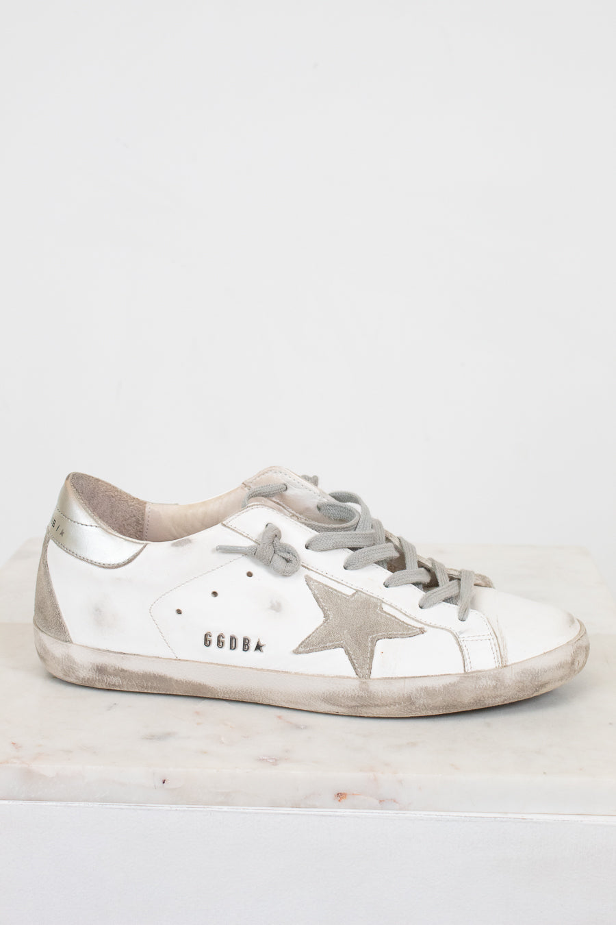 Silver sneaker with a star design on a light gray background