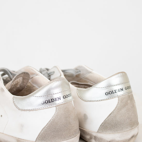 Pair of white and gray sneakers with 'Golden Goose' branding on a light background