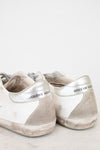 Pair of white and gray sneakers with 'Golden Goose' branding on a light background
