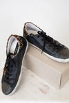 Black sneakers with leopard print accents on a white surface