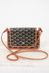 Designer handbag with a patterned flap and brown strap on a white background