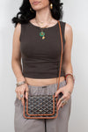 Woman holding a patterned handbag against a plain background