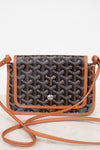 Patterned handbag with brown leather strap on a white background