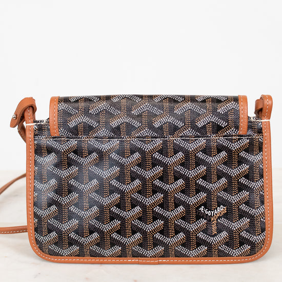 Patterned handbag with brown leather straps on a white background