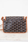 Patterned handbag with brown leather straps on a white background