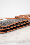 Designer handbag with visible brand pattern on a marble surface