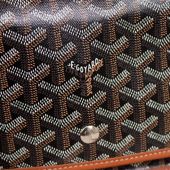 Designer handbag with a distinctive pattern and brand logo on a light background