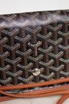 Designer handbag with a distinctive pattern and brand logo on a light background