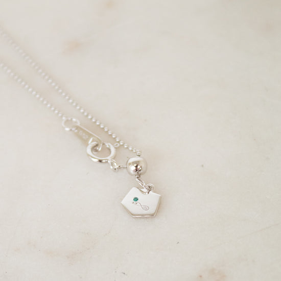 White gold diamond necklace on a marble surface