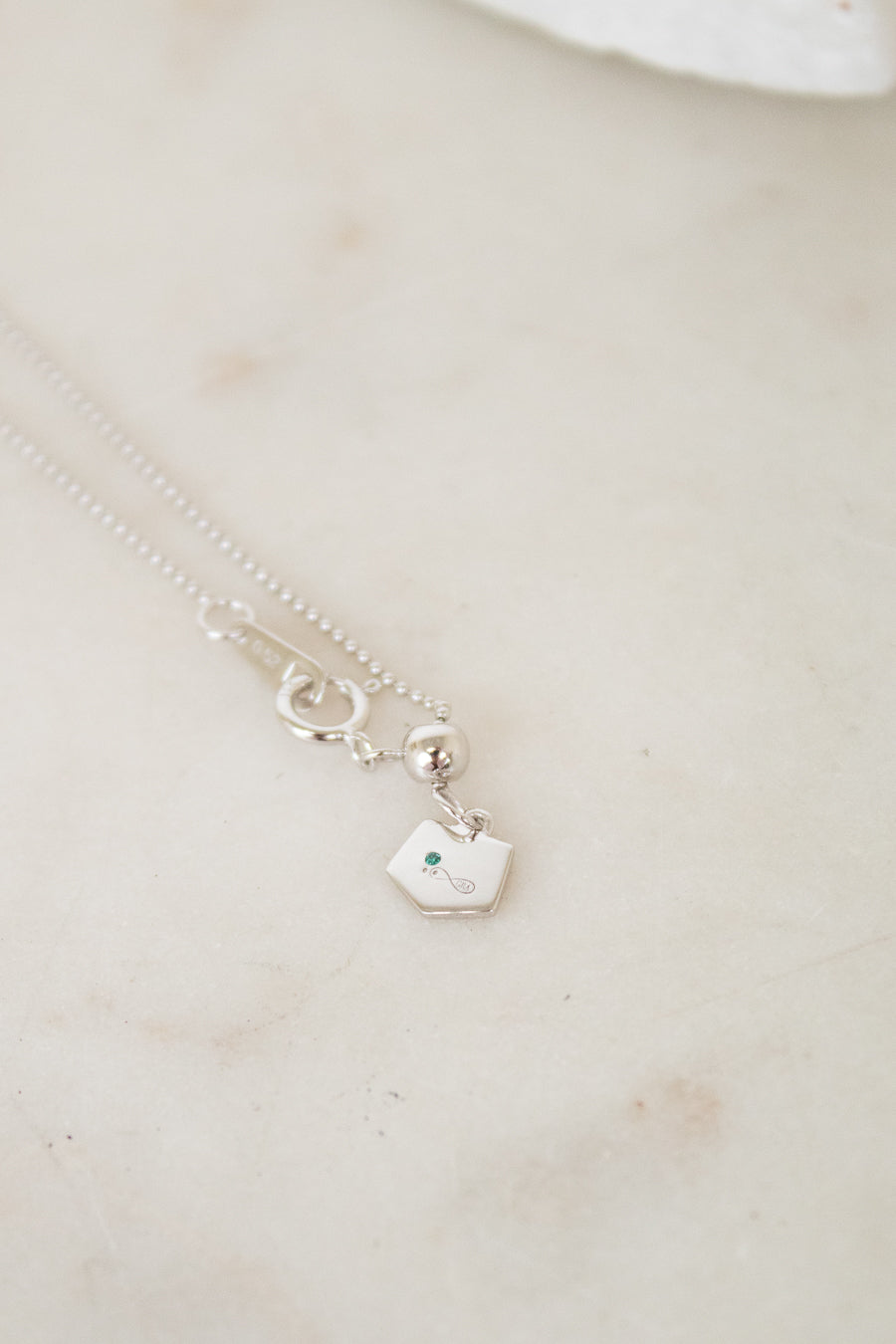 White gold diamond necklace on a marble surface