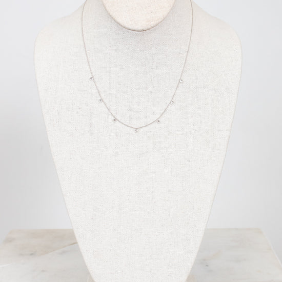 White gold diamond necklace on a marble surface