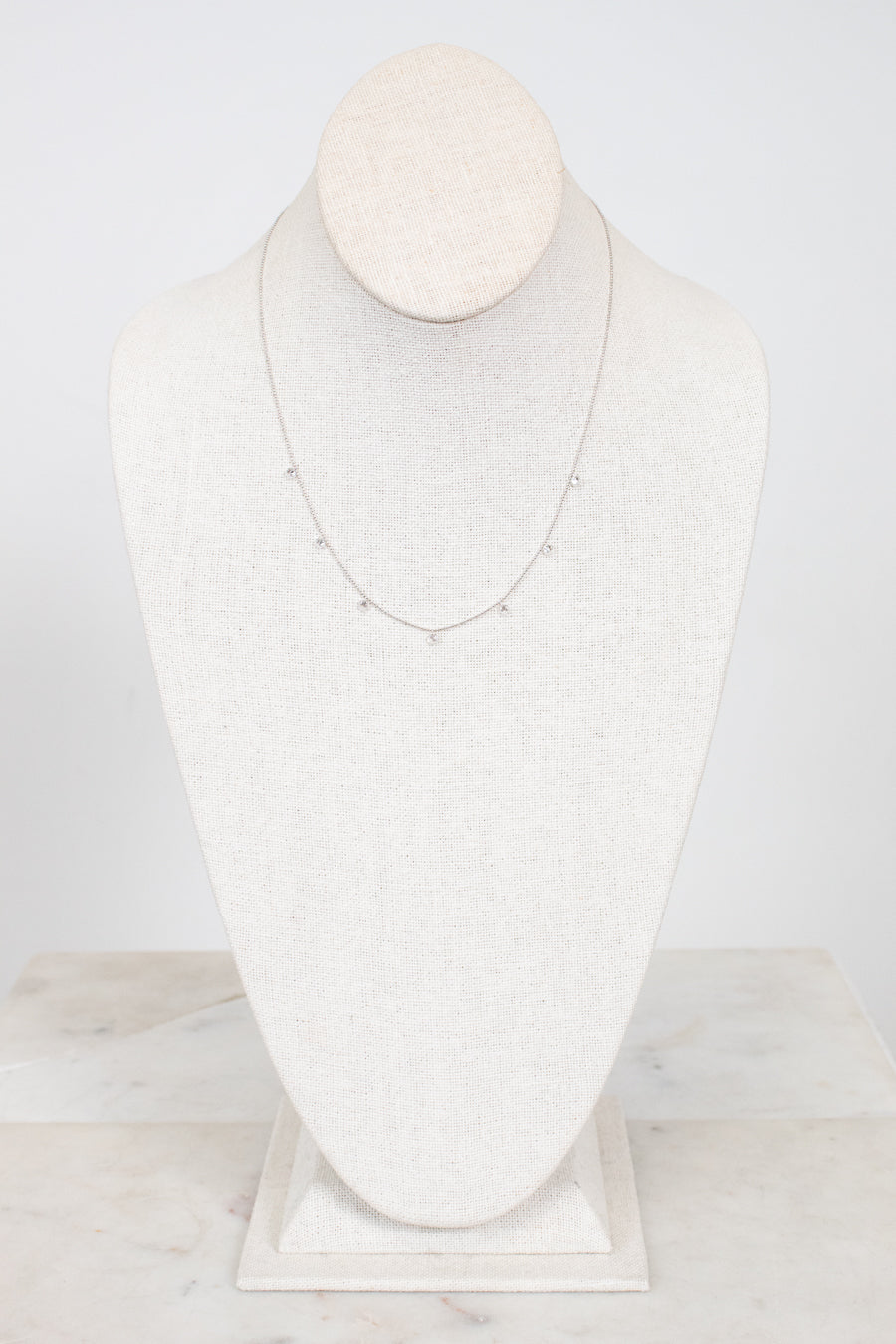 White gold diamond necklace on a marble surface