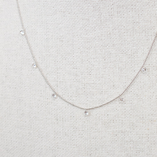 White gold diamond necklace on a fabric surface