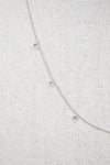White gold diamond necklace on a fabric surface