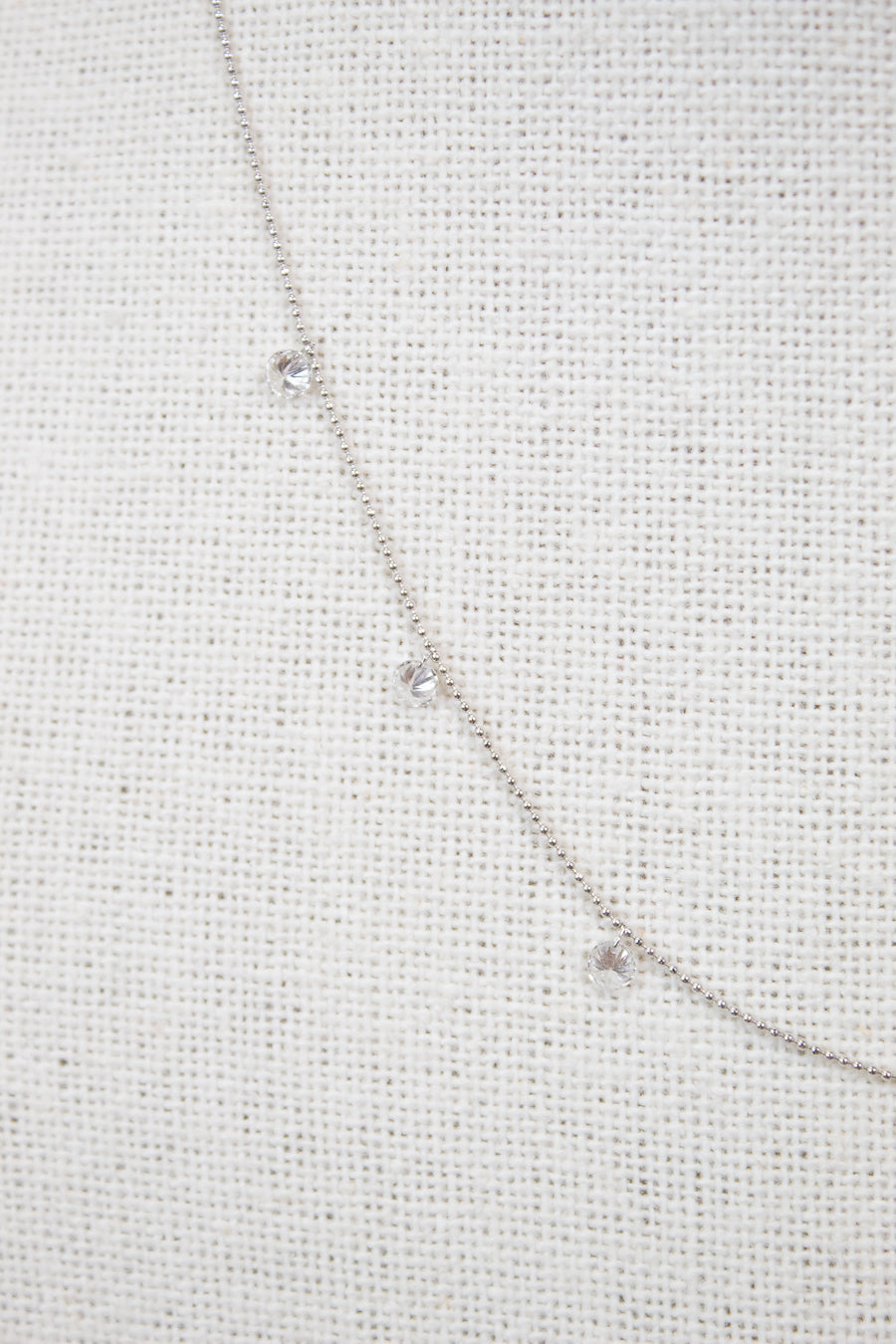 White gold diamond necklace on a fabric surface